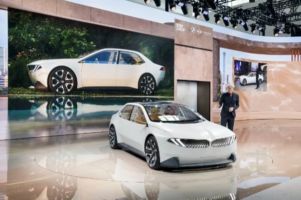 Adrian van Hooydonk steht neben BMW Modellversion der Neue Klasse aus dem Jahr 2024