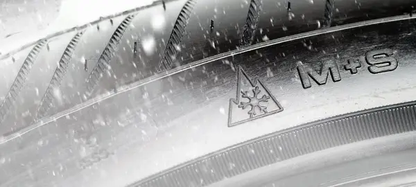 M+S Reifensymbol auf einem Reifen und Schneeflocken