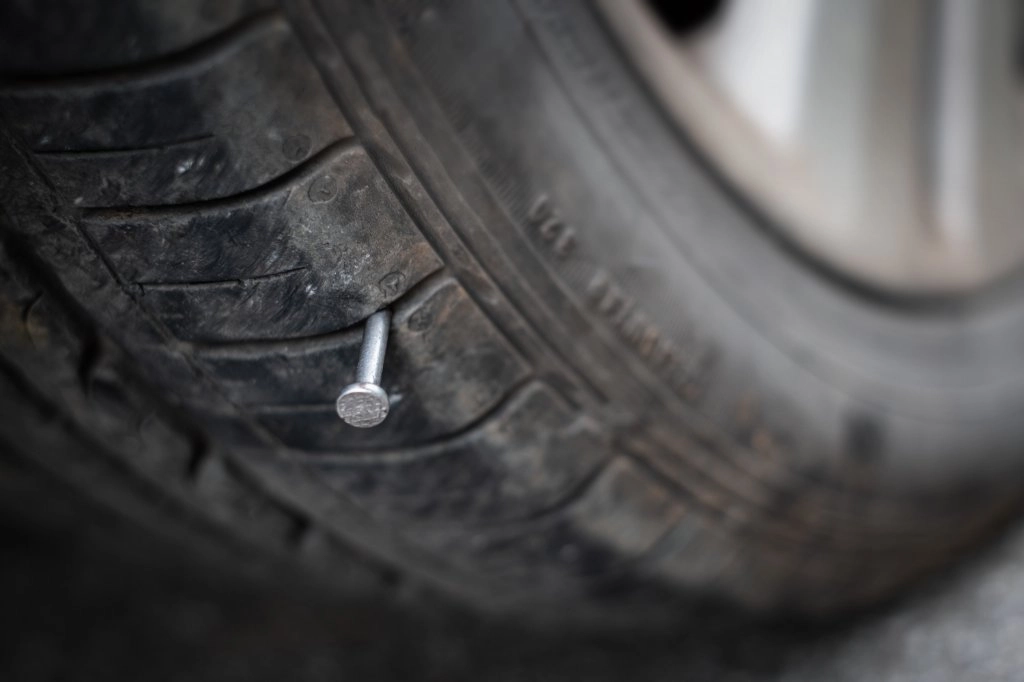 Autoreifen mit Nagel im Reifen