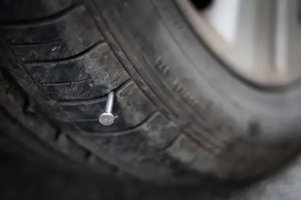 Autoreifen mit Nagel im Reifen