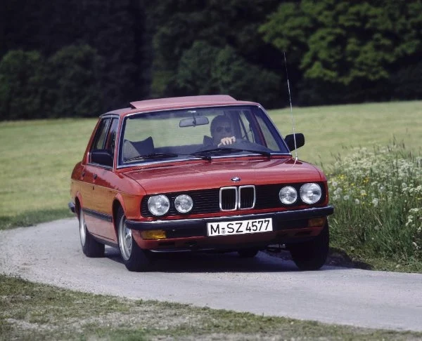 BMW 524td auf schmaler Straße umgeben von Wiese