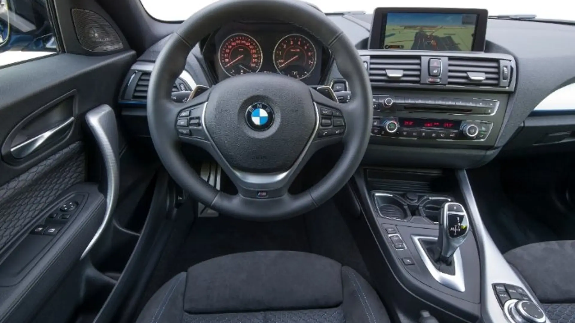 Innenraum eines BMW M135i mit Lenkrad, Mittelkonsole und iDrive-Display