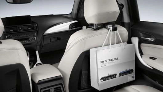 BMW Tasche hängt am Travel & Comfort Basisträger an der Rückseite eines Vordersitzes im Fahrzeuginnenraum