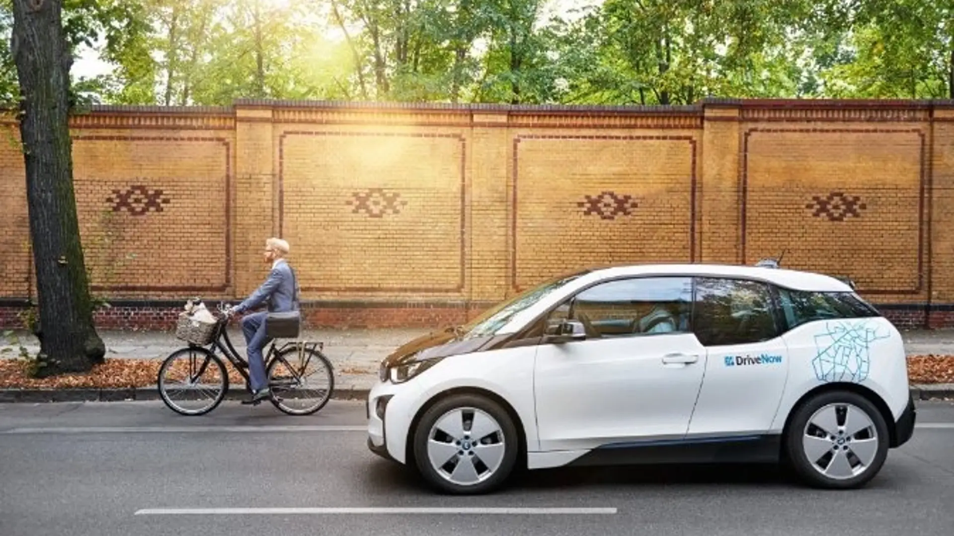 Ein BMW i3 neben einer Fahrradfahrerin