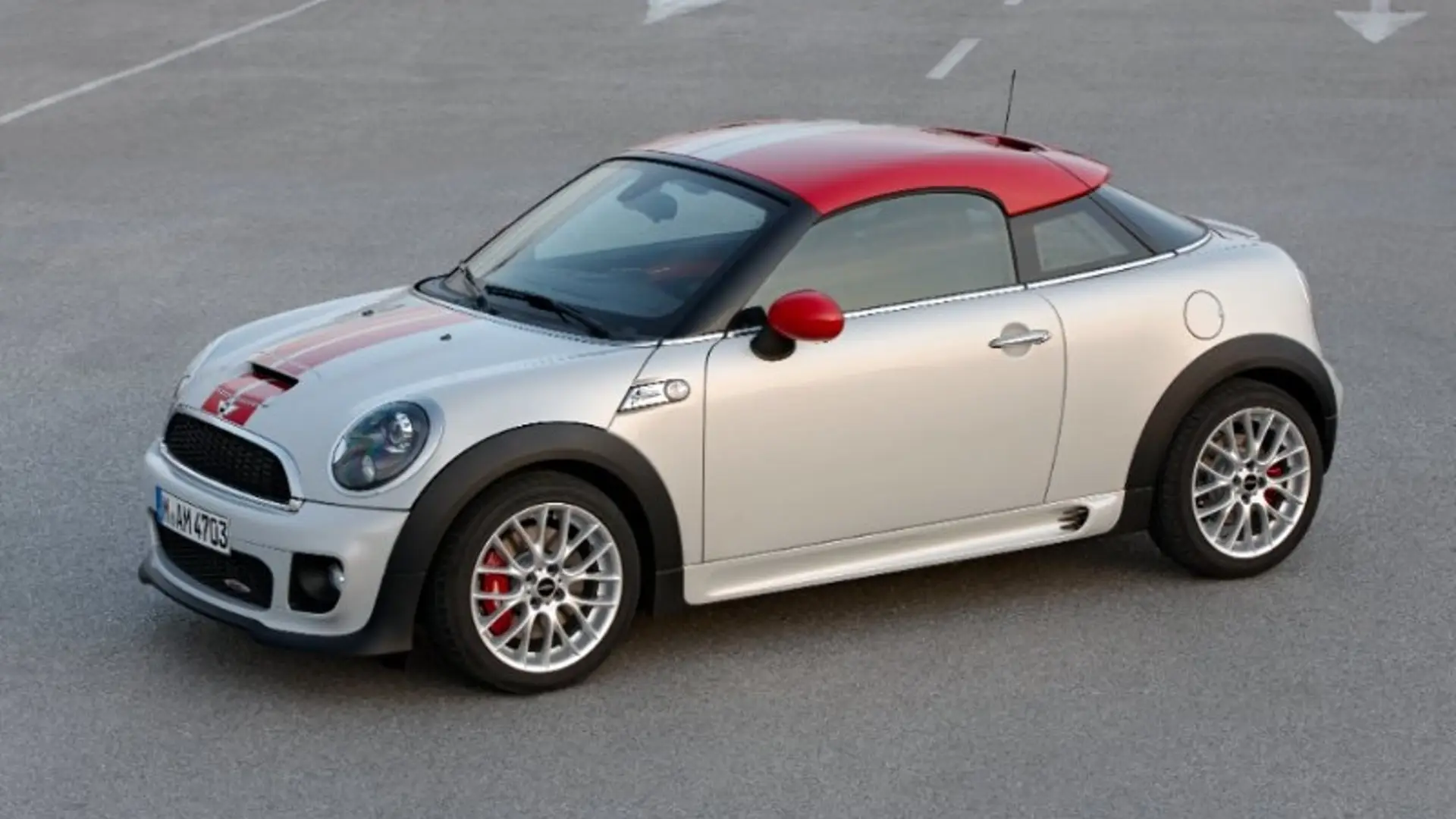 Weißer MINI Coupé Baujahr 2011 mit rotem Dach steht auf Asphaltfläche