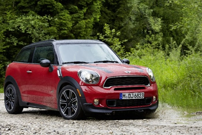 Roter MINI Paceman Cooper S All4 steht auf Schotterweg vor grüner Vegetation