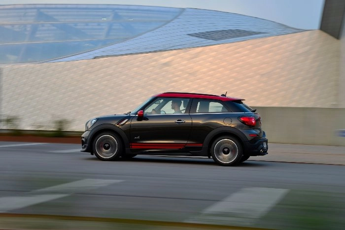 Schwarzer MINI Paceman John Cooper Works fährt an moderner Architektur vorbei