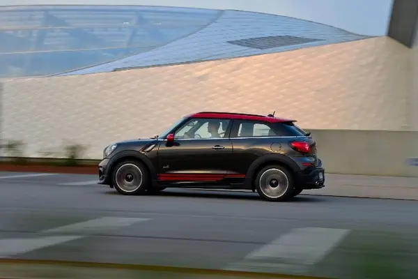 Schwarzer MINI Paceman John Cooper Works fährt an moderner Architektur vorbei