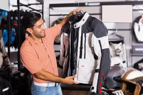 Ein Mann hebt eine Motorradjacke an