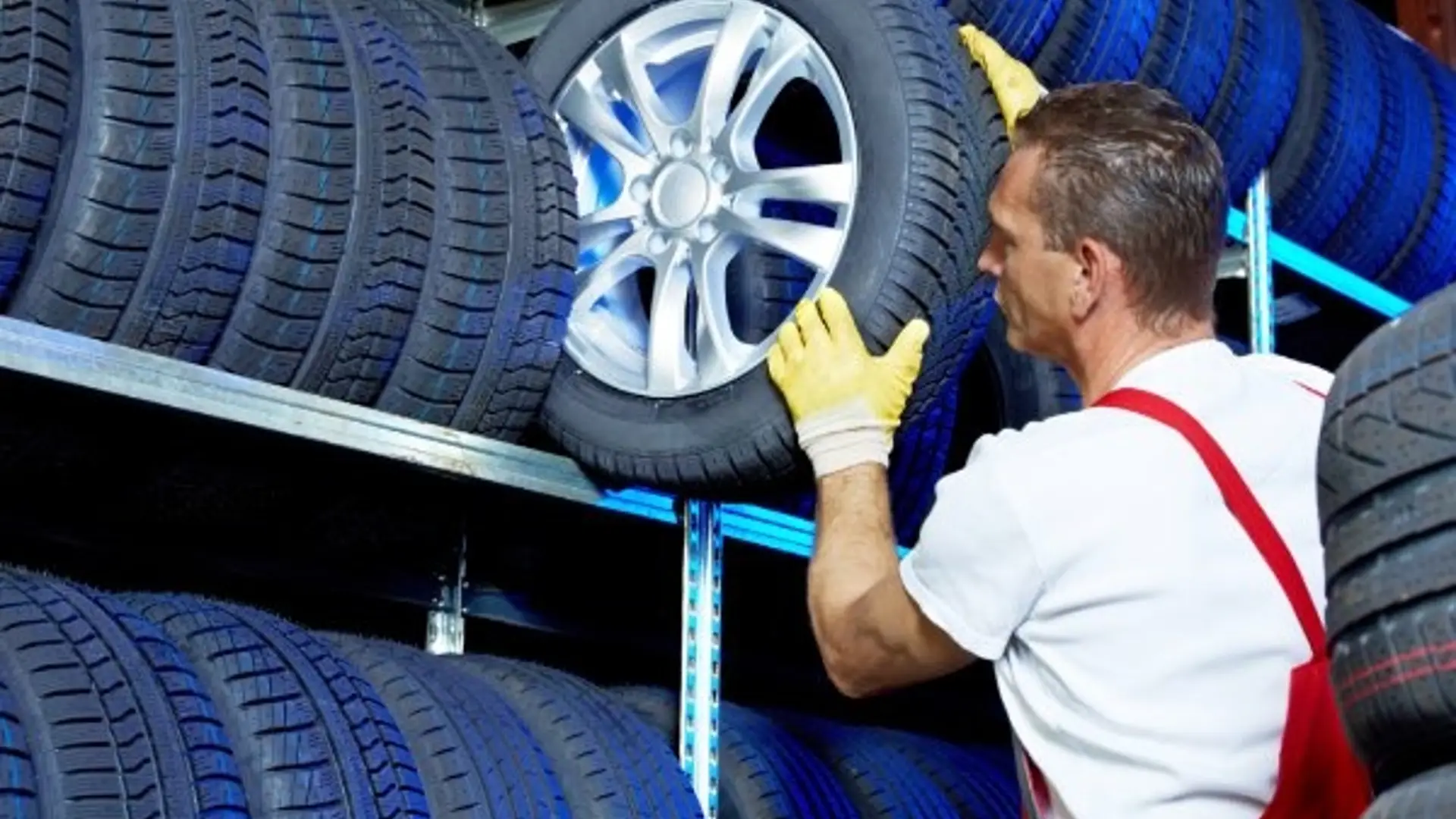 Autowerkstatt-Mitarbeiter lagert Reifen im Regal ein