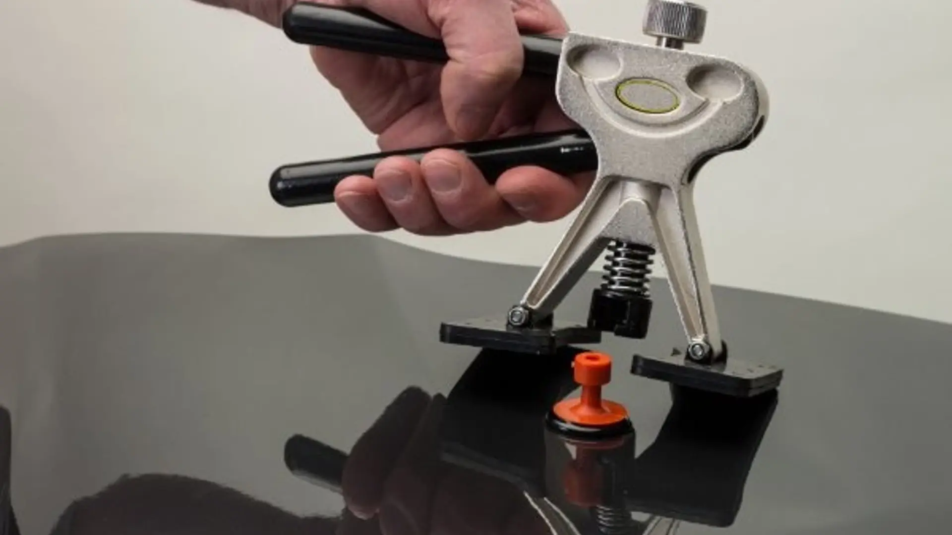 Werkzeug zur Smart-Repair-Methode wird auf Autolack gesetzt, um eine Delle auszubessern