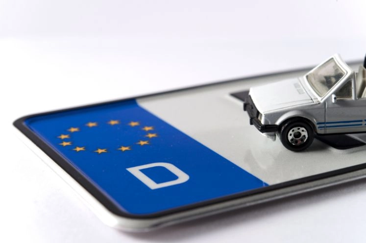 Ein liegendes Kennzeichen mit einem Modelauto darauf