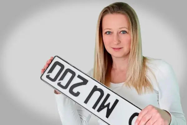 Eine Frau mit einem Kennzeichen in der Hand