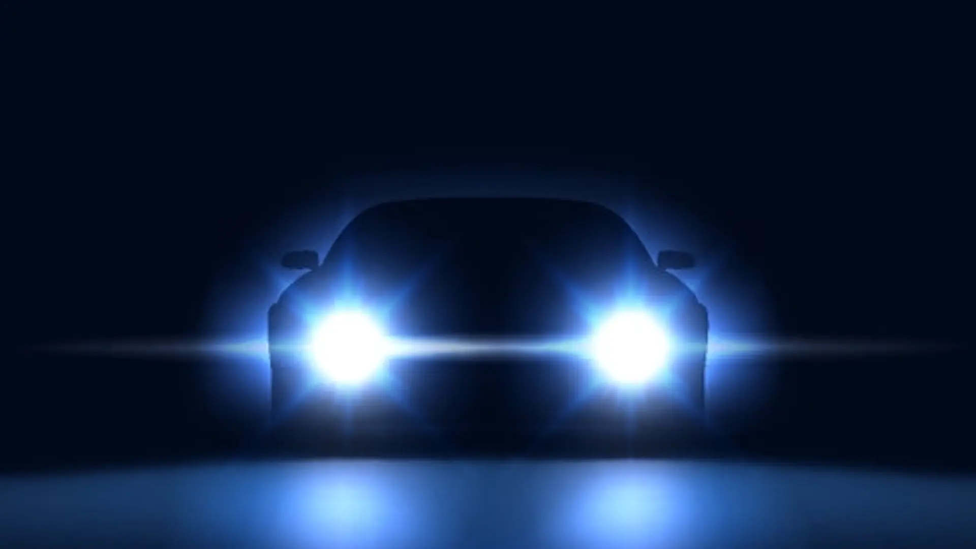 Frontansicht eines Autos im Dunkeln mit eingeschalteten Xenon-Scheinwerfern